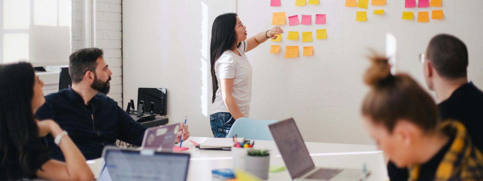 woman placing sticky notes on wall